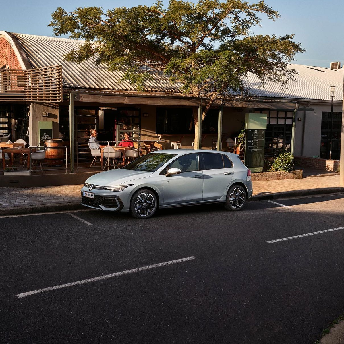 Der neue Golf GTE parkt an einem Straßenrand neben einem Café.