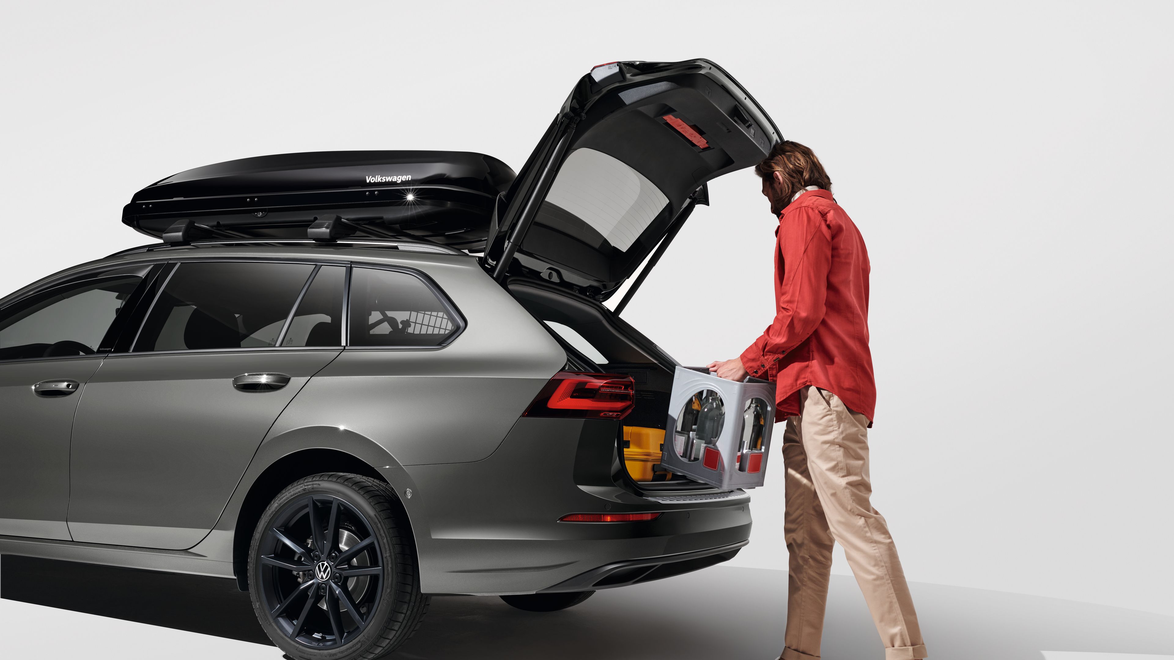Ein Mann belädt den Kofferraum eines Volkswagen Golf Variant