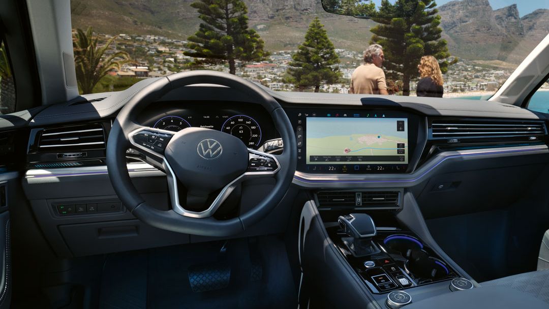 Blick in das vordere Cockpit des VW Touareg, im Hintergrund ein Paar