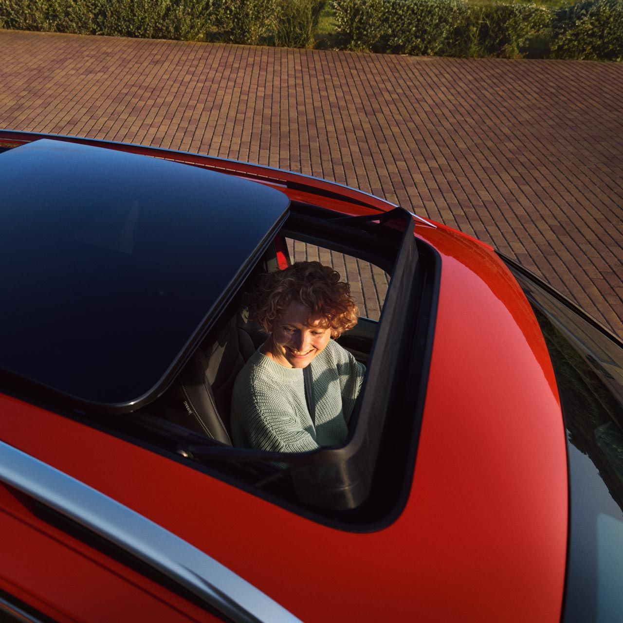 Blick in den VW Tiguan durch das Panoramadach, im Auto sitzt eine Frau