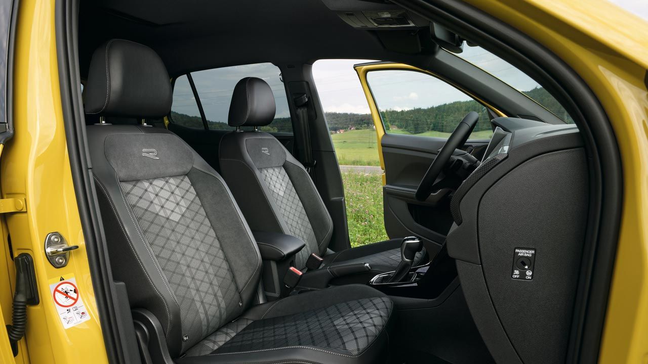 Blick durch die Beifahrertür des gelben VW T-Cross mit den optionalen Sport Komfortsitzen