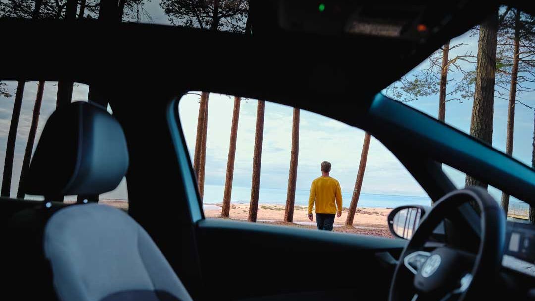 Blick durch das Fenster eines IDs auf einen Mann, der am Strand spaziert