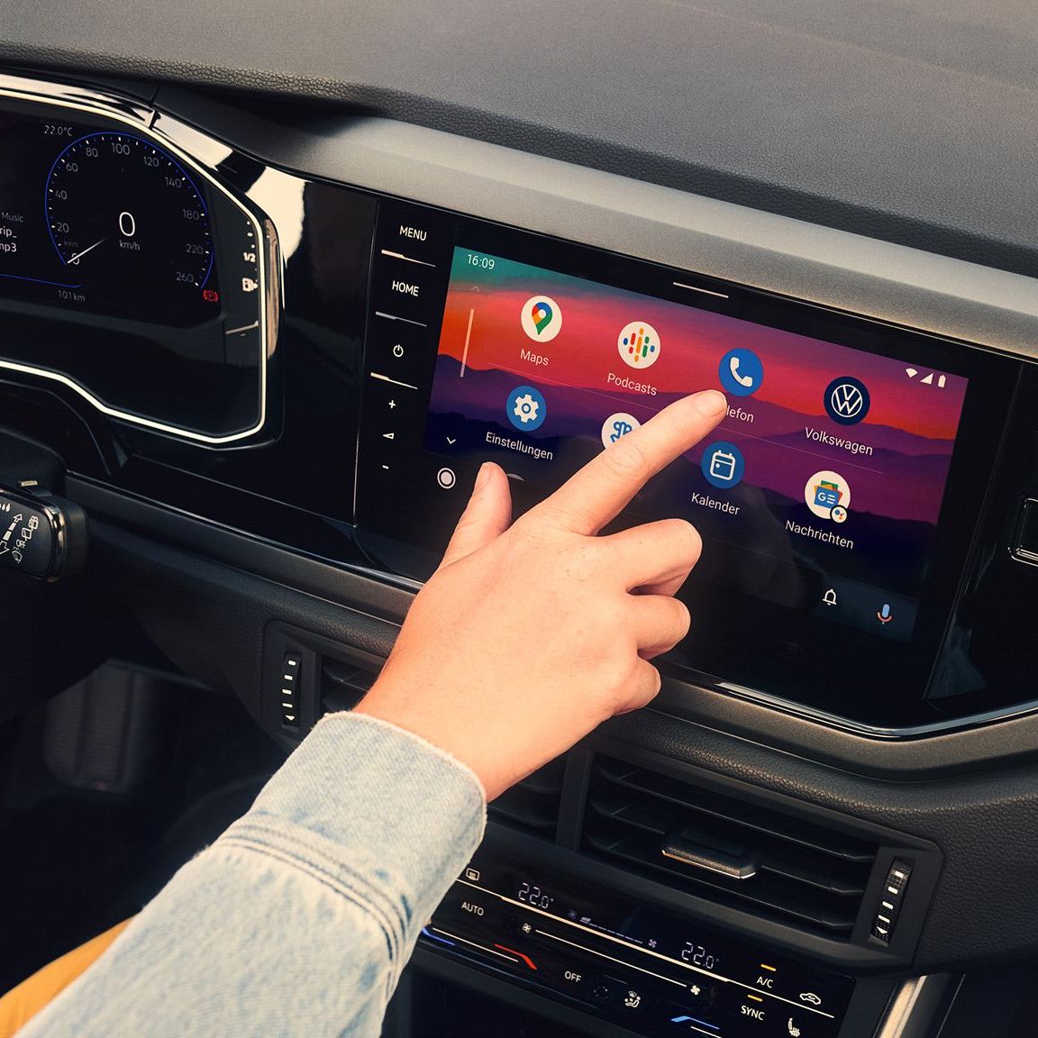 Display des Infotainmentsystems im VW Polo mit Android Auto™ von Google. Eine Frau sitzt auf dem Fahrersitz und bedient das Display. 