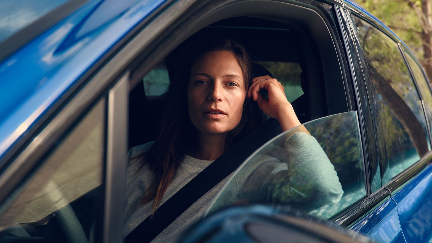 Eine Frau sitzt in einem VW Touareg R eHybrid und blickt in die Kamera