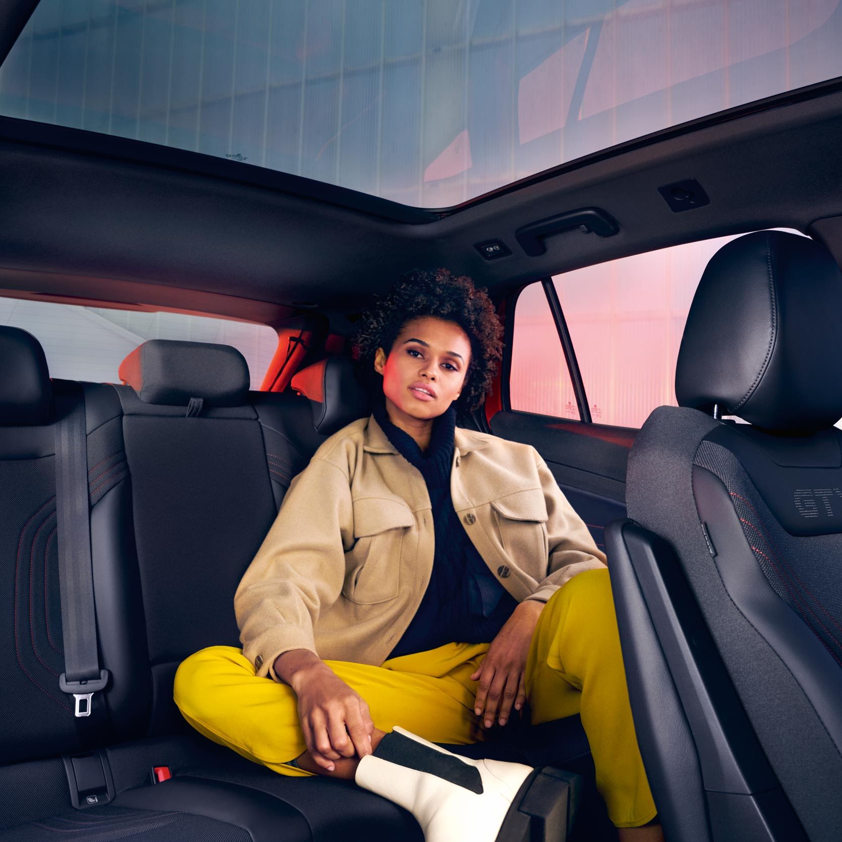 Innenansicht des VW ID.4 GTX, Frau sitzt auf der Rückbank mit blick nach vorne.