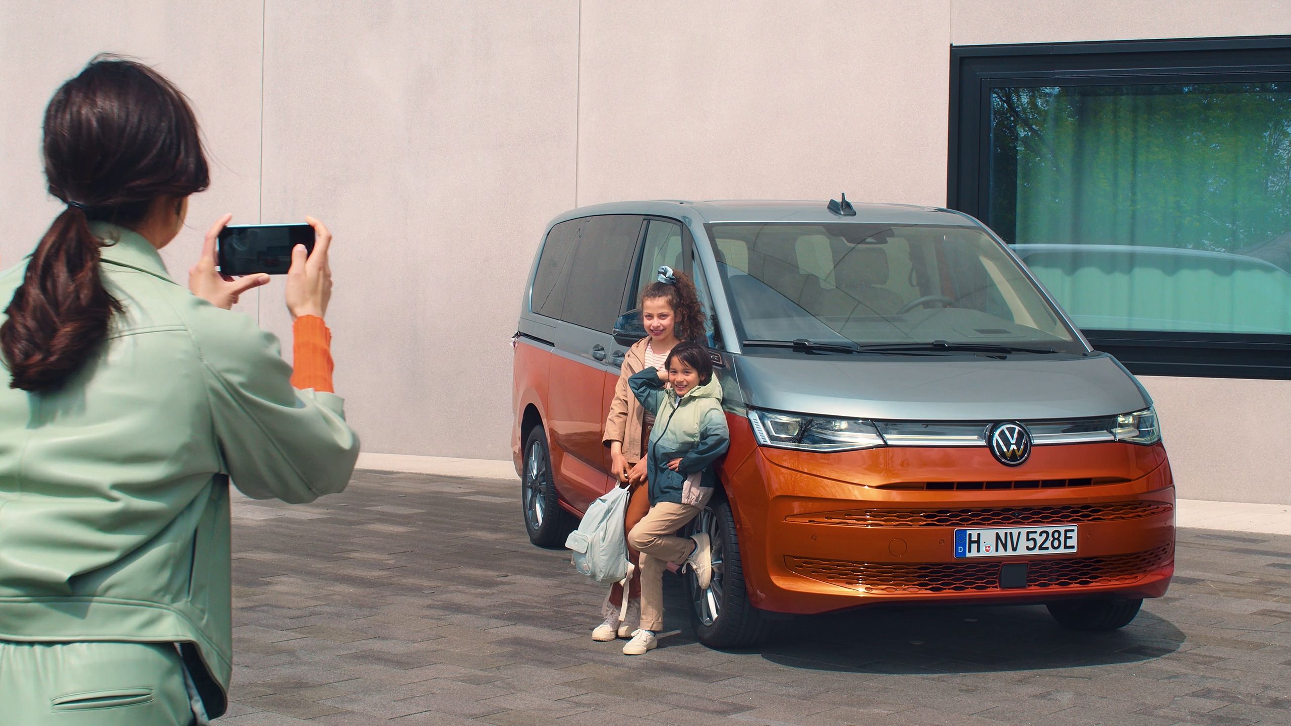Frau schießt Foto von Kindern vor neuem VW T7 Multivan