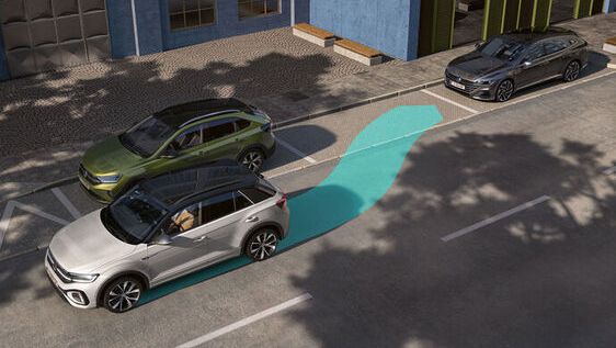 Das Bild zeigt einen Volkswagen T-Roc beim Parallelparken. Die Unterstützung durch den Parkassistenten "Park Assist" ist blau gekennzeichnet.