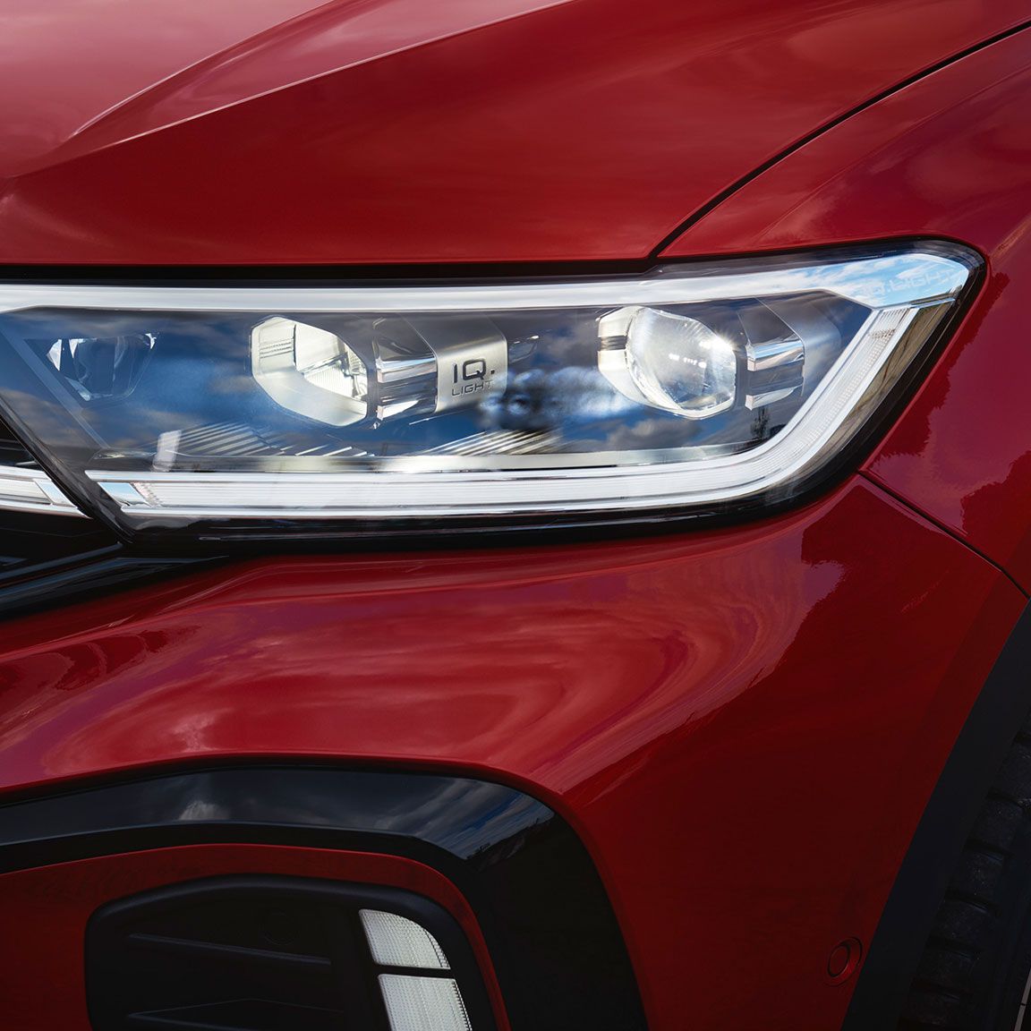 Detail des rechten Frontscheinwerfers IQ.LIGHT im VW T-Roc Cabriolet in Rot.