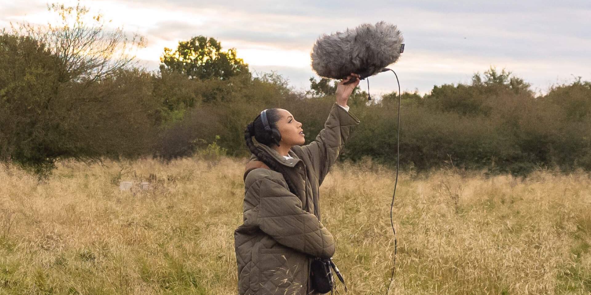 Jayda G hält Mikrofon in der Natur