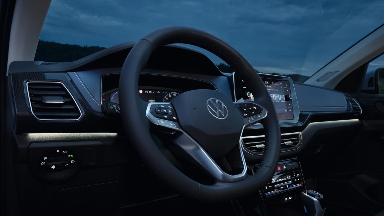 Detailansicht bei Nacht auf das Cockpit des VW T-Cross mit Fokus der weißen Ambientebeleuchtung