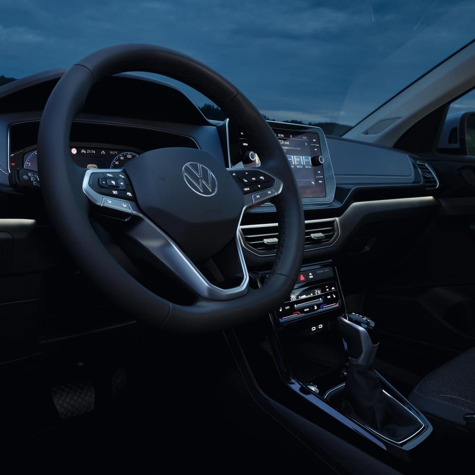 Detailansicht bei Nacht auf das Cockpit des VW T-Cross mit Fokus der weißen Ambientebeleuchtung