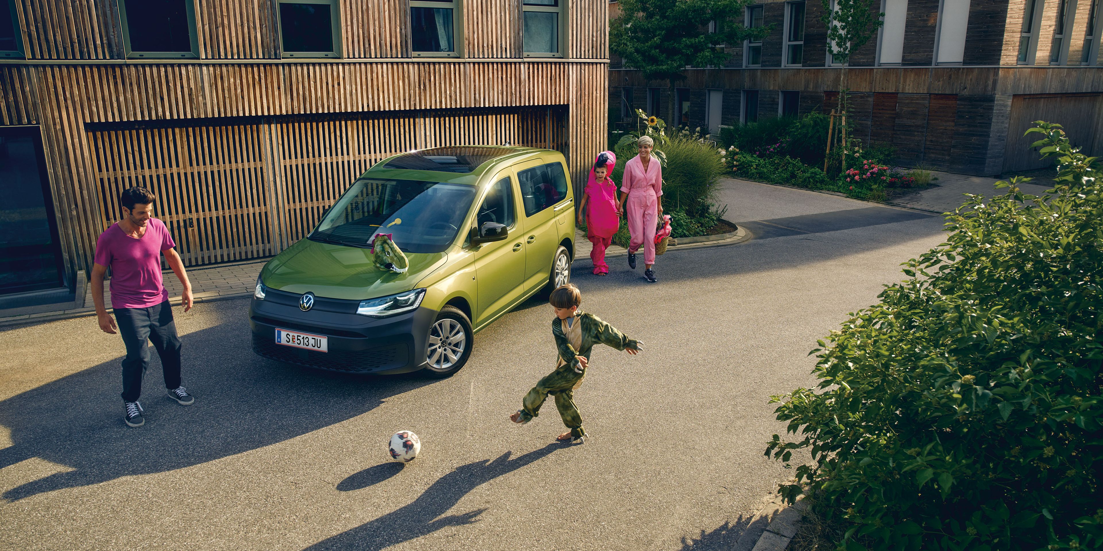 Kinder spielen vor einem Volkswagen Caddy