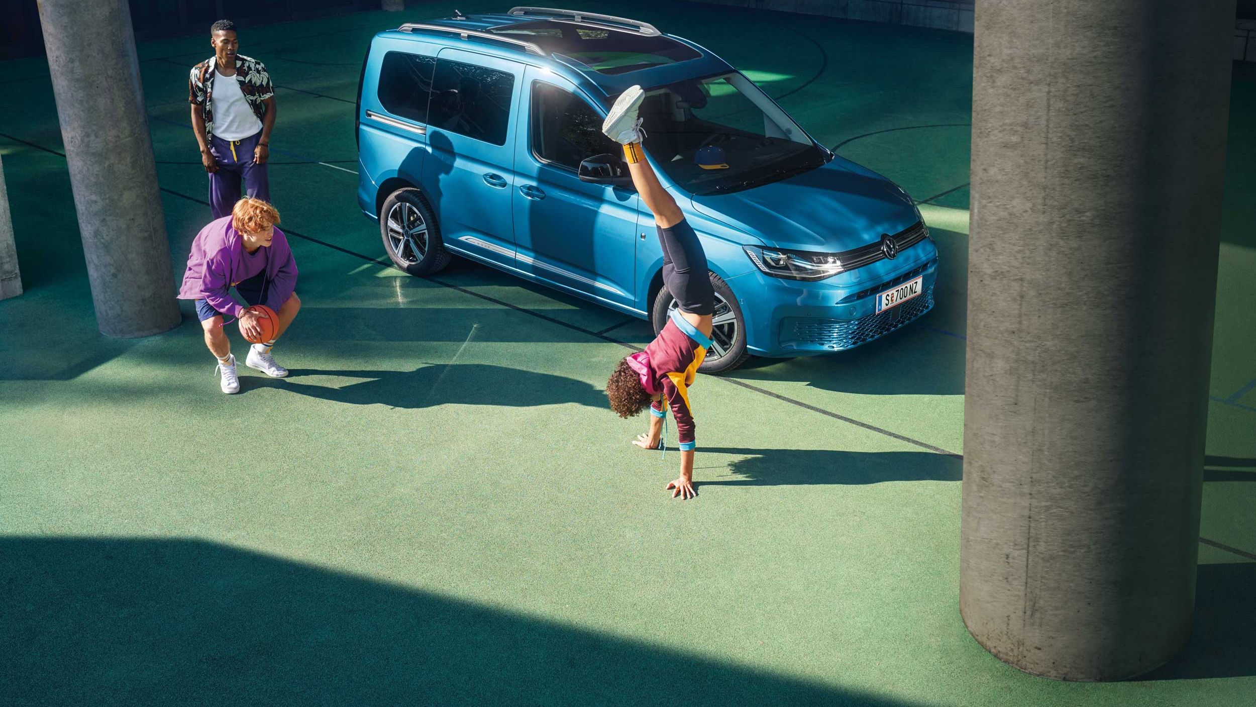 Kinder spielen vor einem VW Caddy