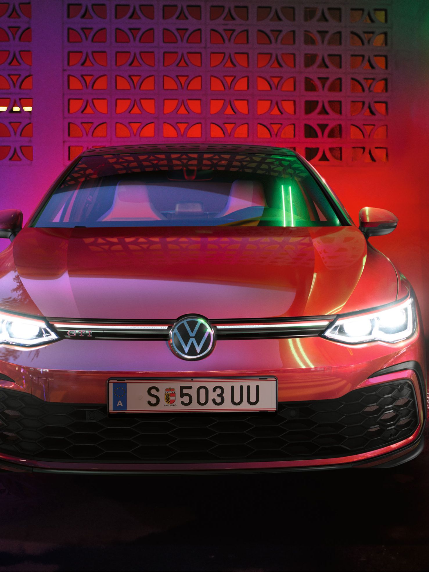 Frontansicht des VW Golf GTI mit bunten Lichtern im Hintergrund