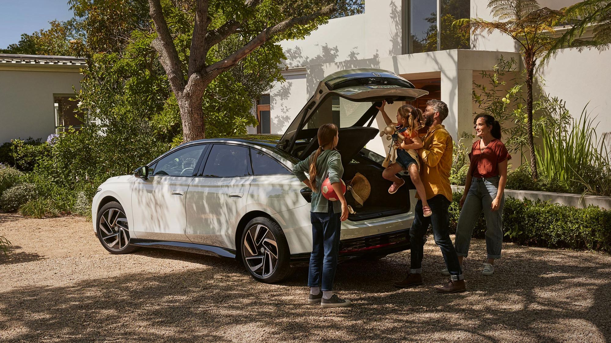 Familie räumt den Kofferraum eines weißen VW ID.7 ein