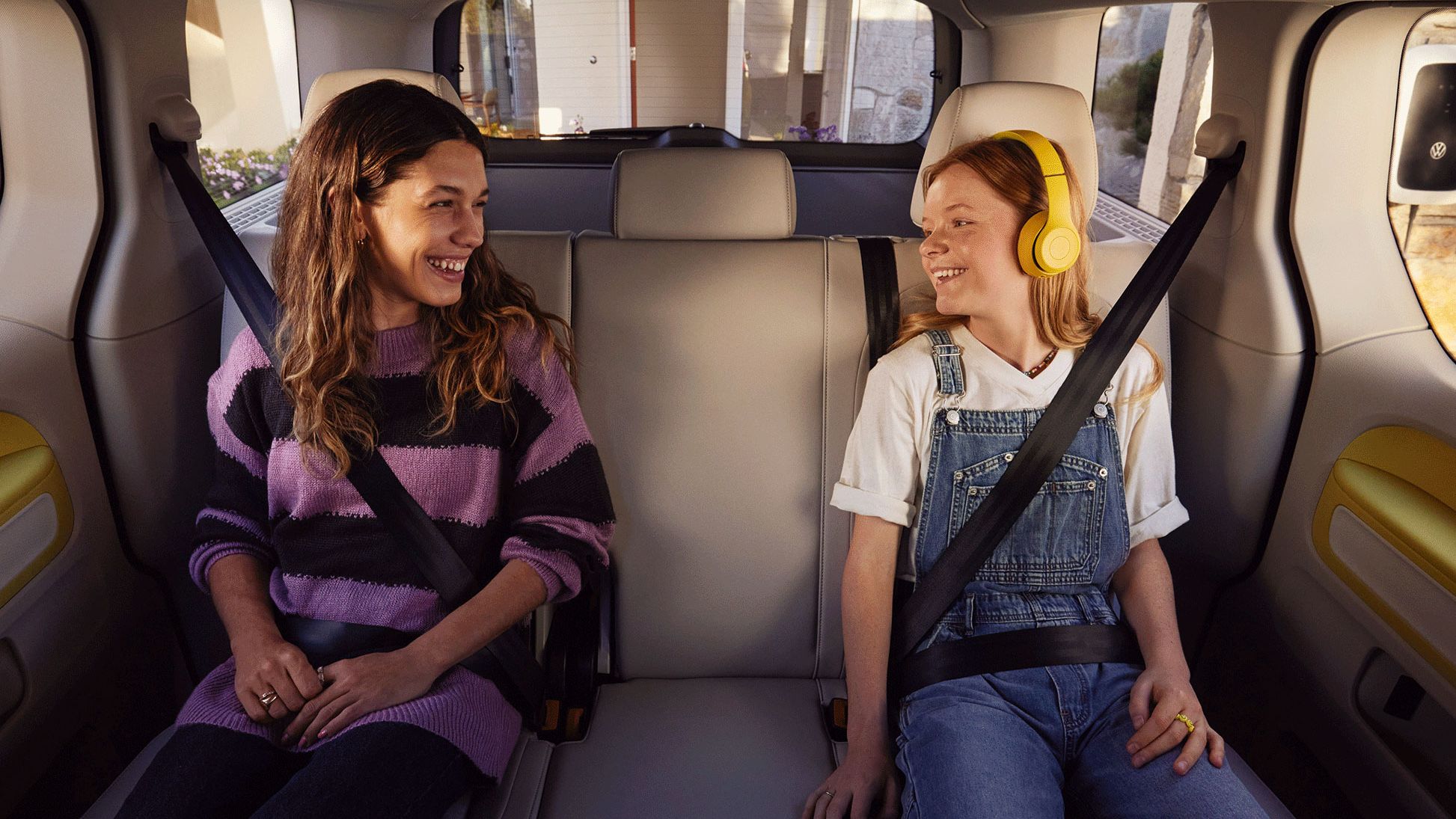 Zwei Mädchen sitzen auf der Rückbank des VW ID. Buzz.