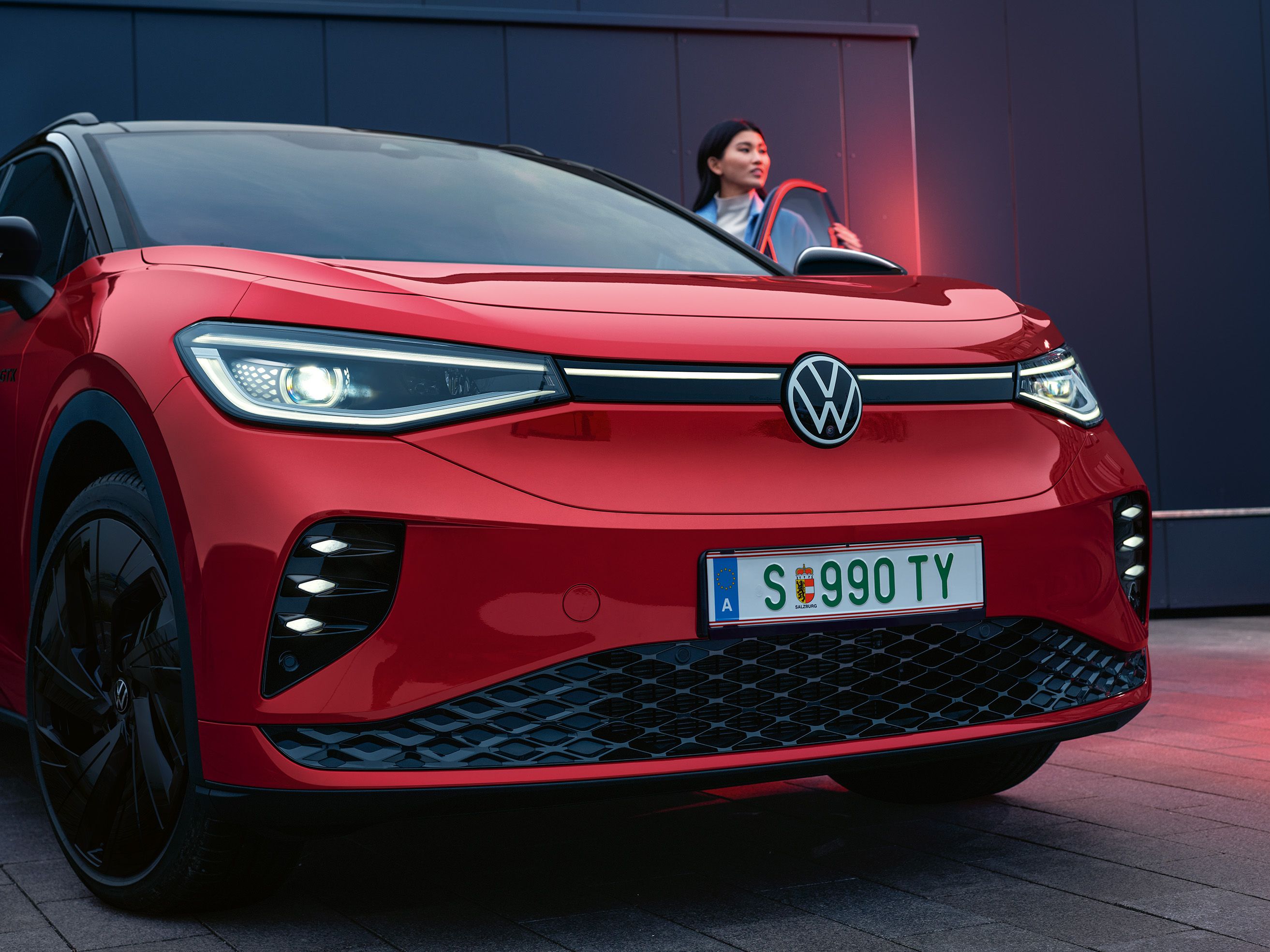 Detailansicht der Frontpartie des VW ID.4 GTX, Frau steigt ein