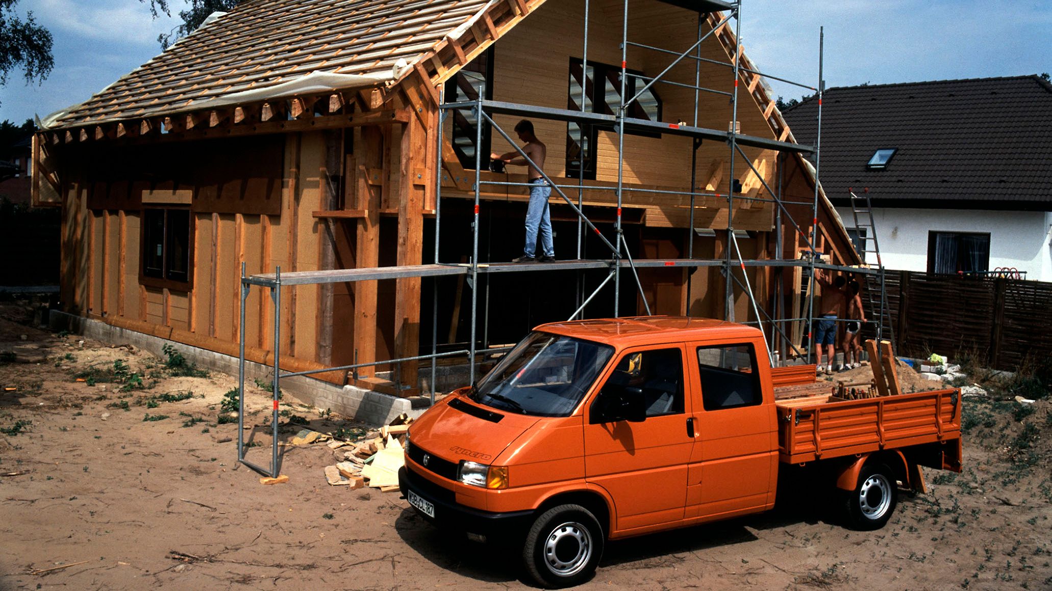 Orangener VW Bulli T4 Pritschenwagen mit Doppelkabine 