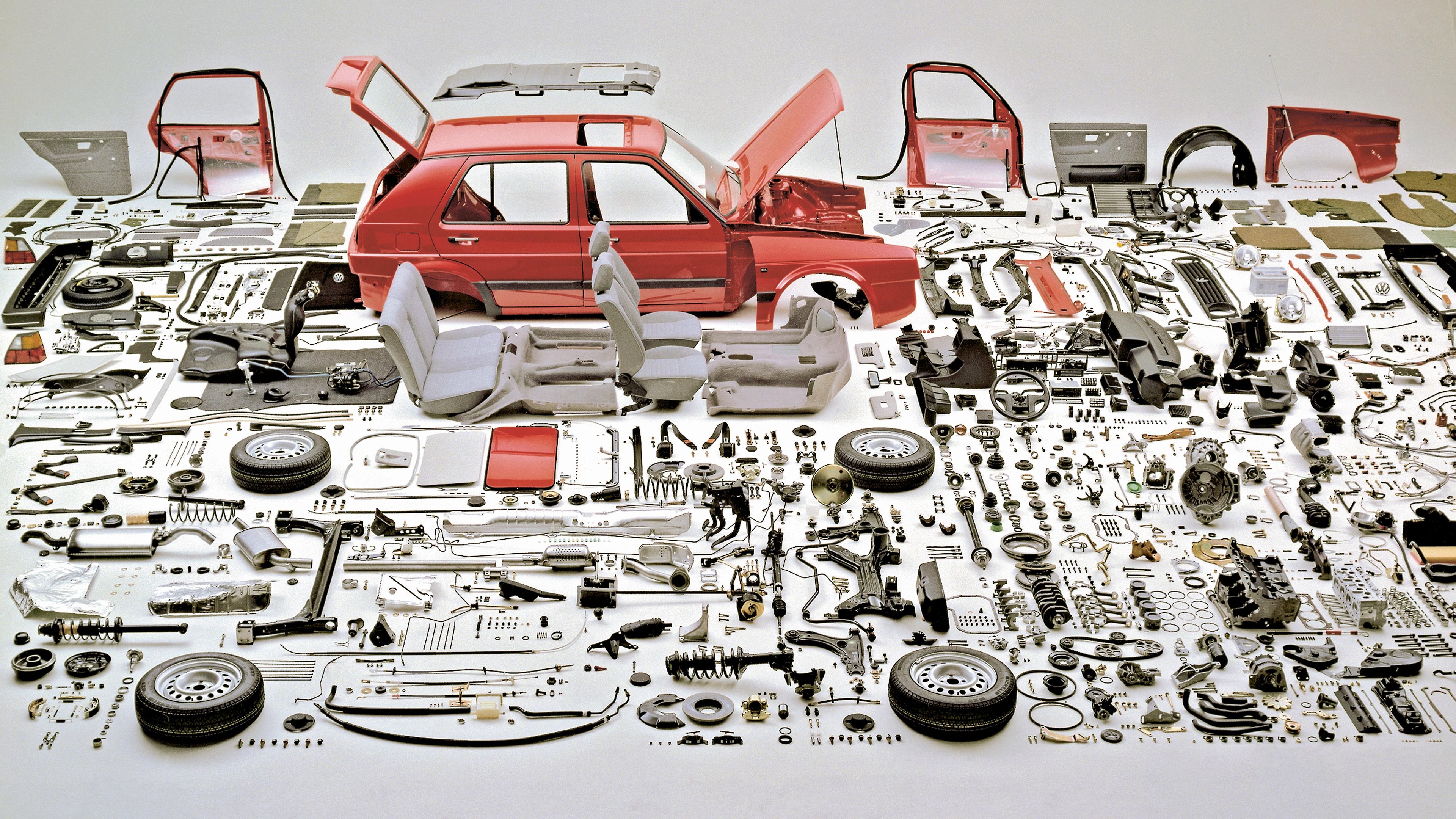 Ein VW ist umgeben von seinen VW Classic Parts Einzelteilen. 
