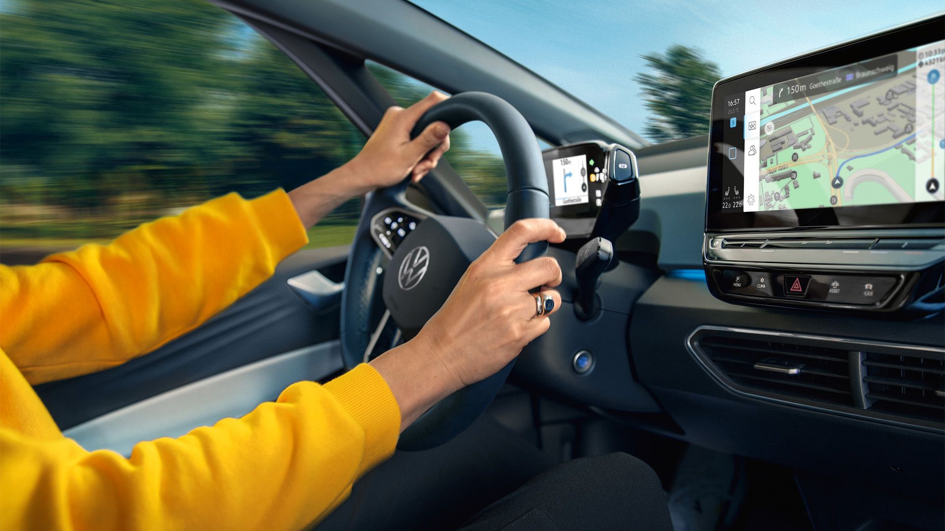 Detailaufnahme des Lenkrads und des Touchscreens im VW ID.3, Arme des Fahrers am Lenkrad sind zu sehen