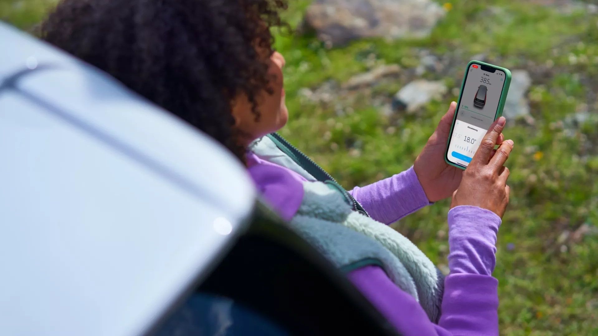 Eine Frau steuert die Klimaanlage eines VW ID. Buzz über die We Connect App