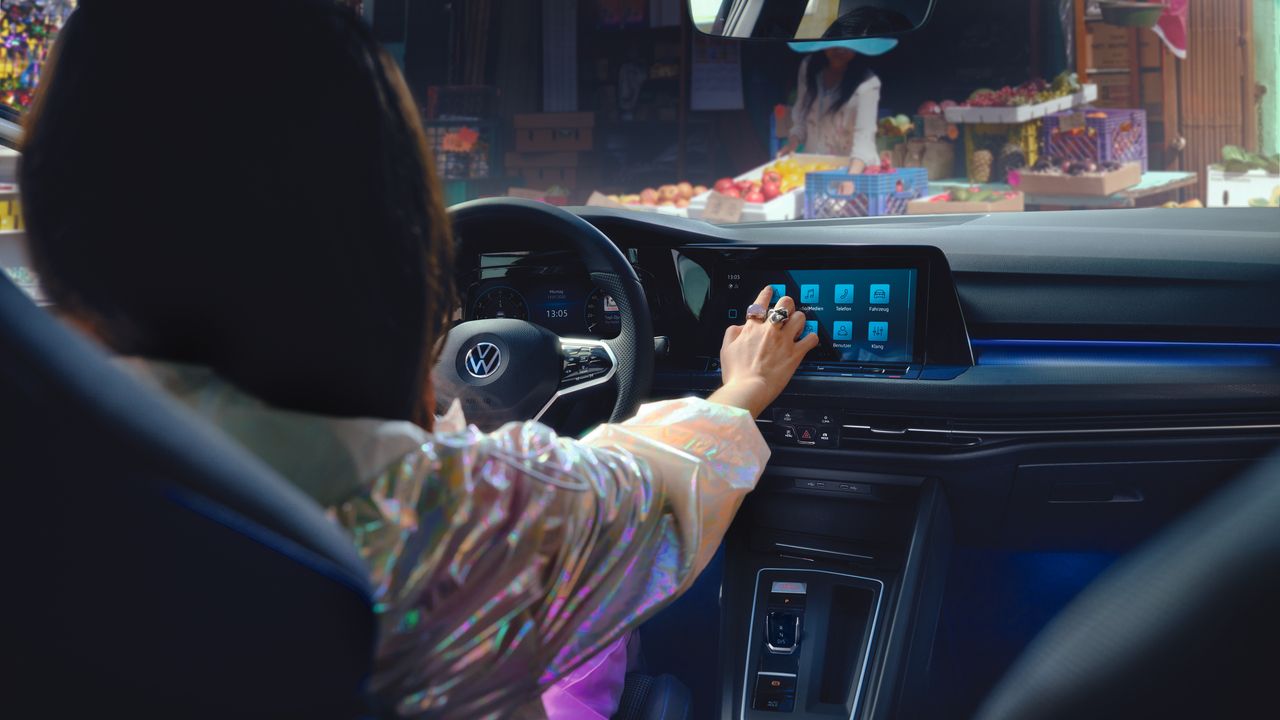 VW Golf GTE Interieur, Blick ins Cockpit, Frau bedient Touchscreen des Infotainment-Systems