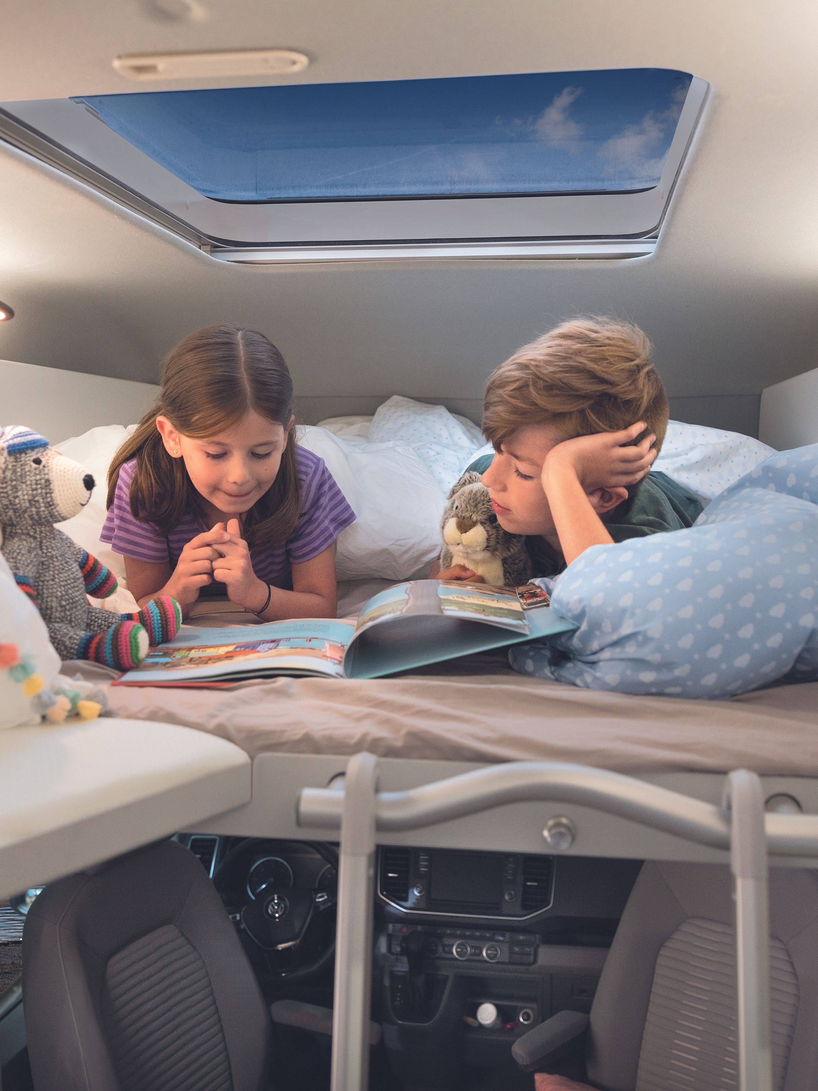 Zwei Kinder liegen auf dem Heckbett im VW Grand California.