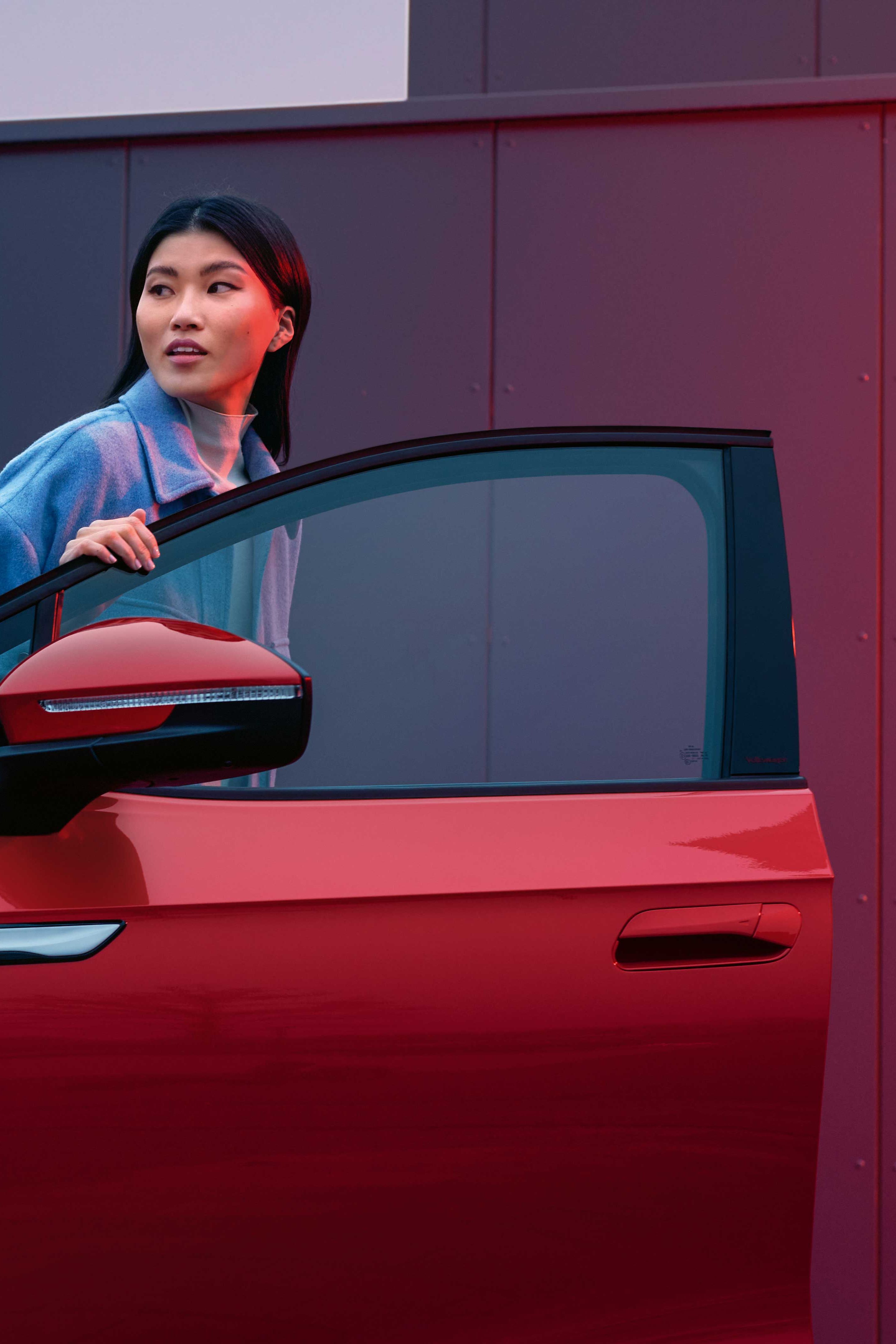 Frau steigt aus roten VW ID.4 GTX