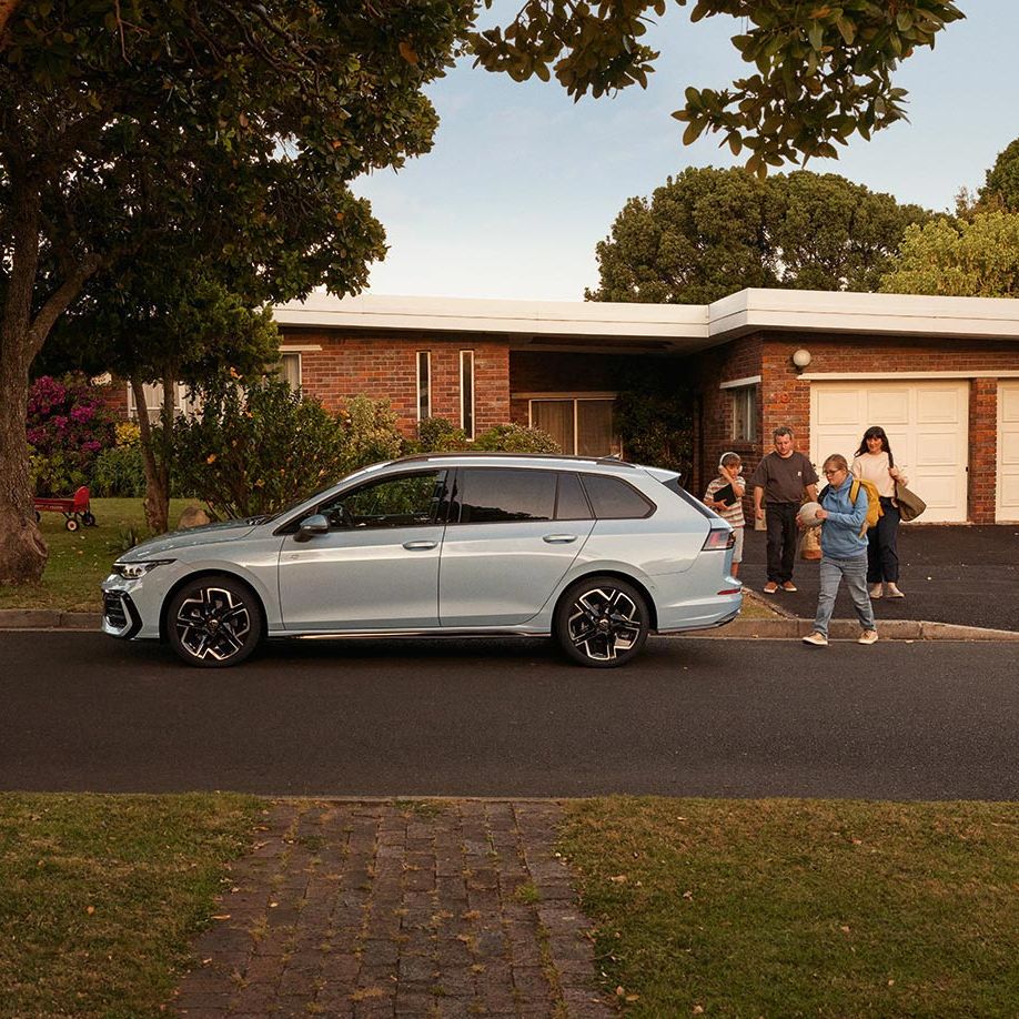 Seitenansicht eines VW Golf Variant in der Farbe Ice Blue Metallic geparkt vor Einfamilienhaus
