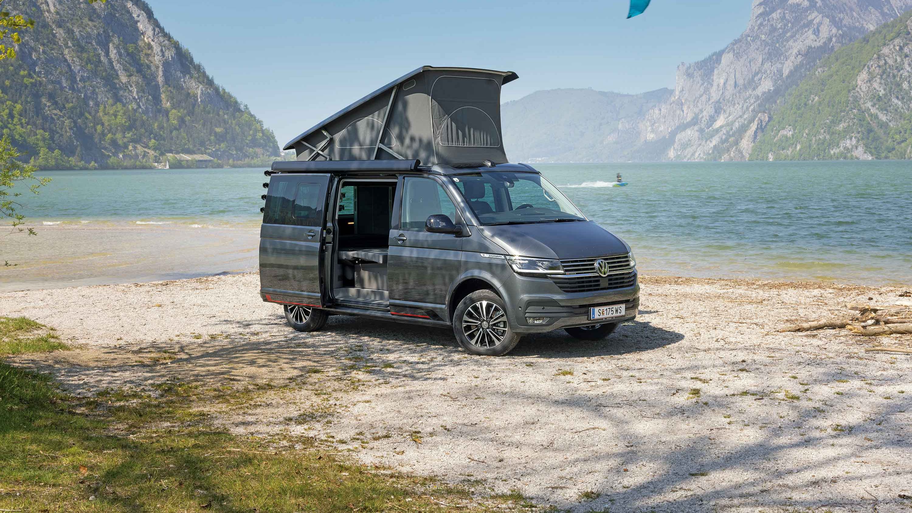 VW California 6.1 Edition geparkt vor See und Bergkulisse