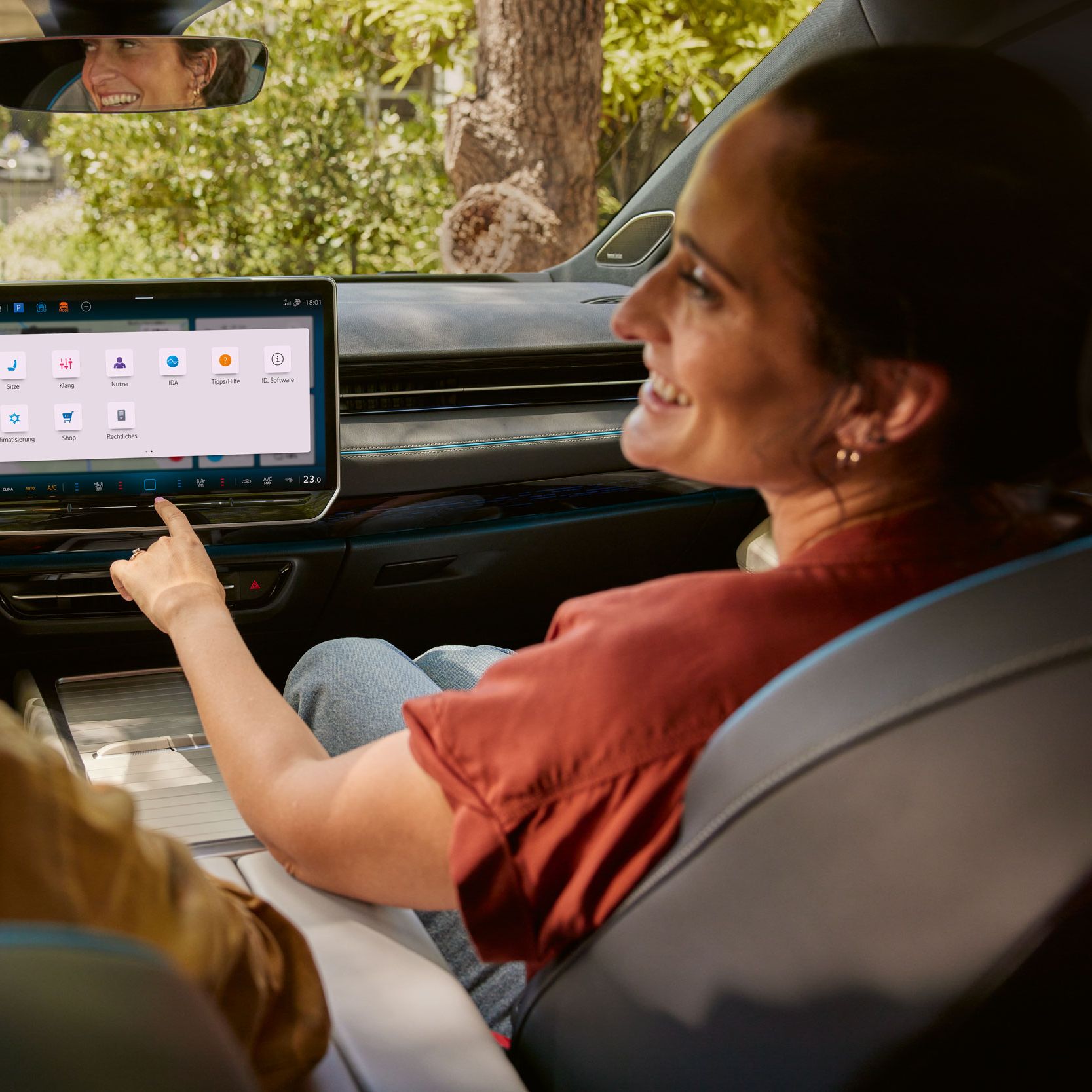 Mann und Frau sitzen in einem VW ID.7, brauch bedient Infotainmentsystem