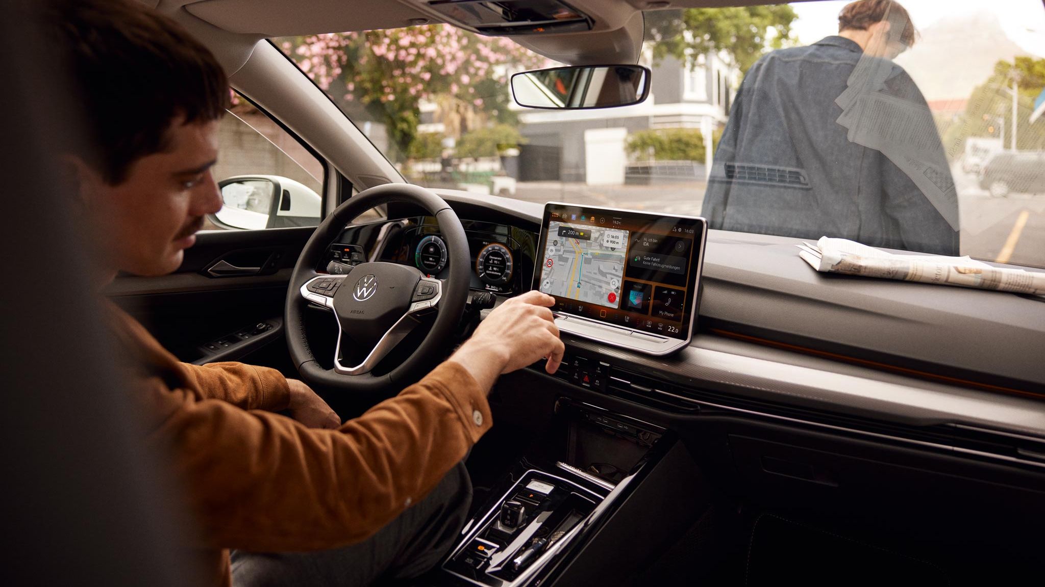 Man bedient Touchscreen des Infotainmentsystems im VW Golf