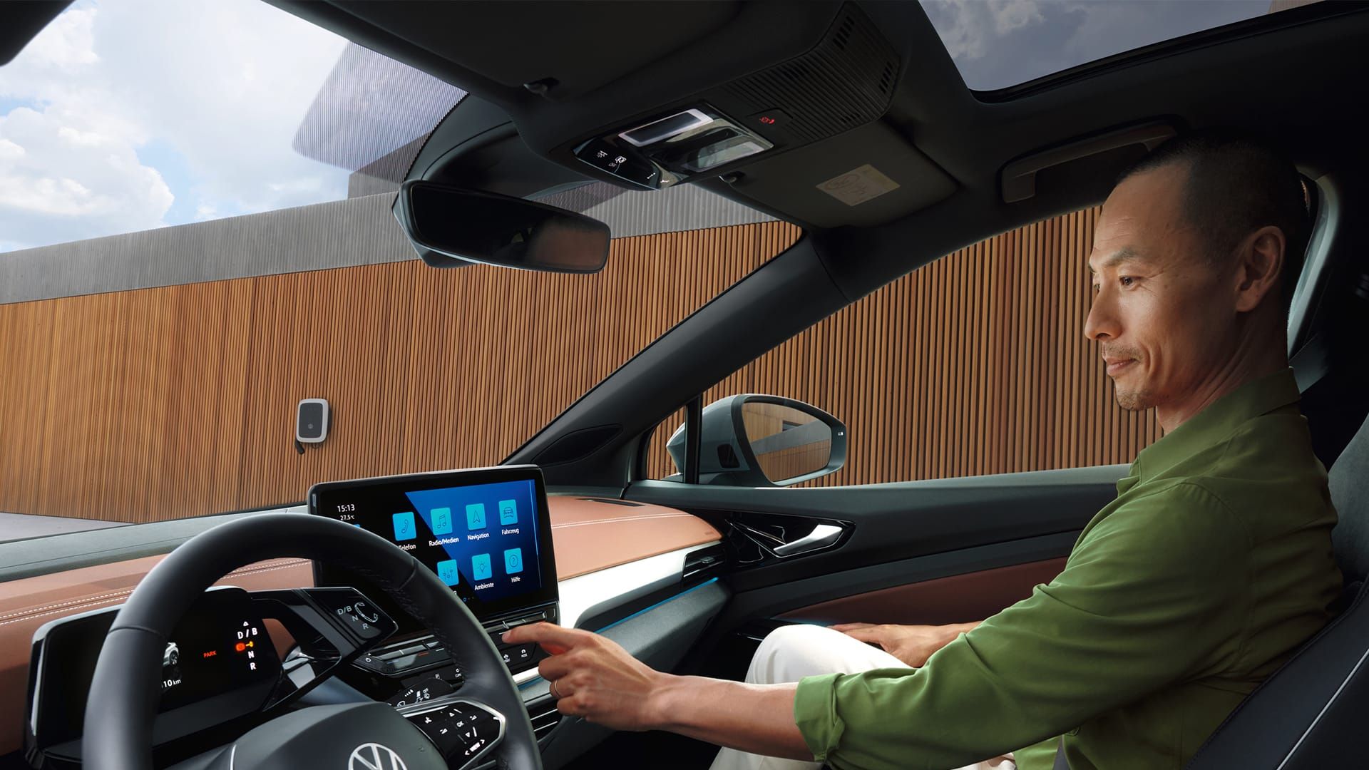 Blick in das Cockpit eines VW ID.5. Mann sitzt auf Beifahrersitz und bedient das Infotainment-System