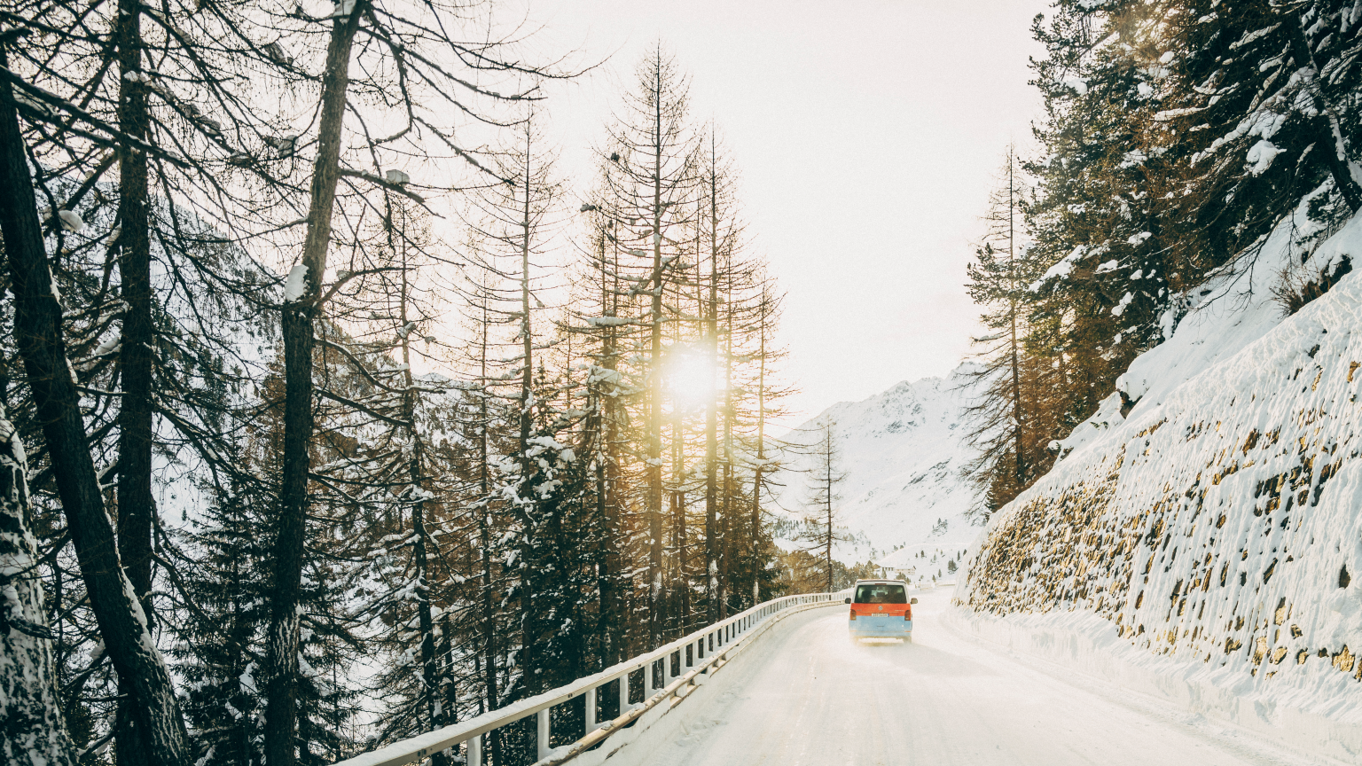 Ein Volkswagen Nutzfahrzeug fährt eine winterliche Straße entlang