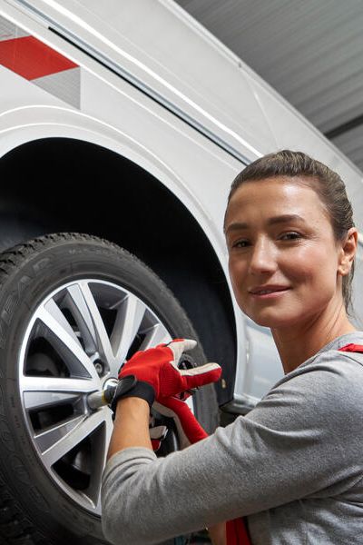 Eine Volkswagen Technikerin beim Reifenwechsel