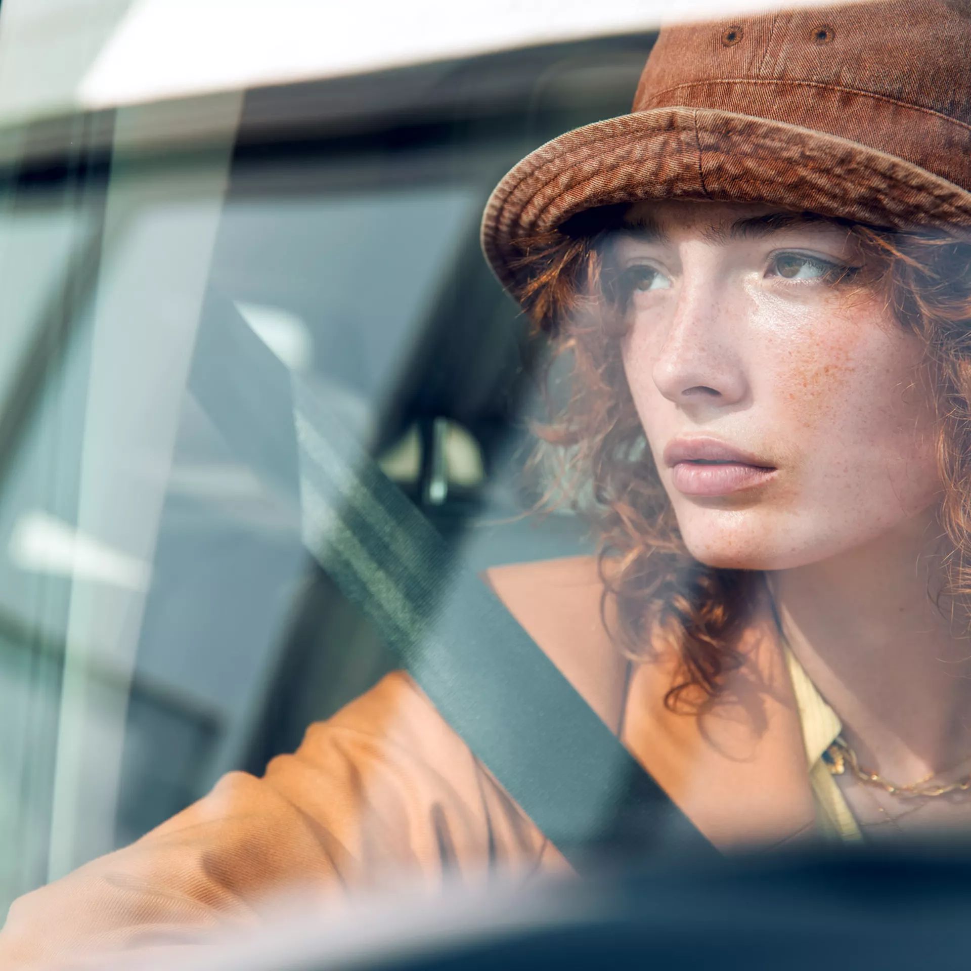 Frau blickt durch das Fenster eines VW Multivan