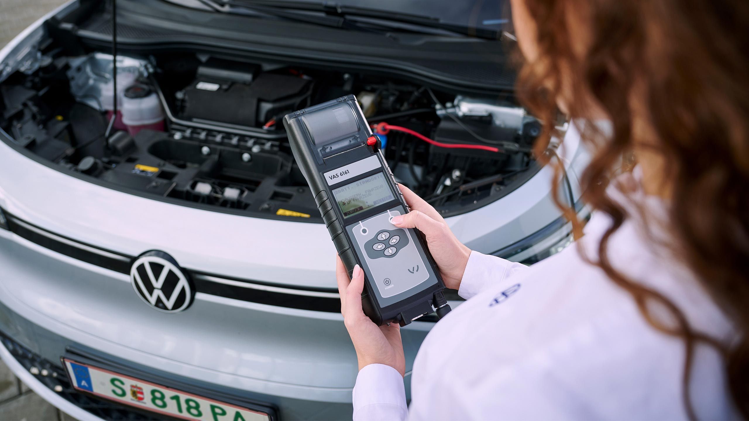 Eine VW Technikerin beim Elektroautoservice für einen Volkswagen ID