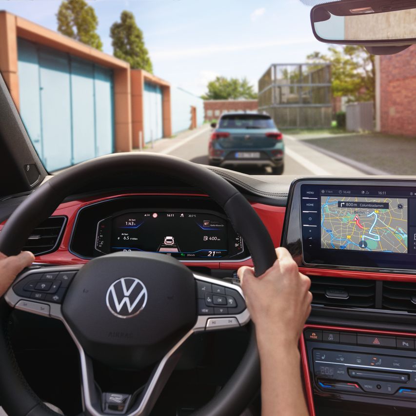 Cockpit des VW T-Roc Cabriolet, zwei Hände am Steuer, Blick durch die Windschutzscheibe