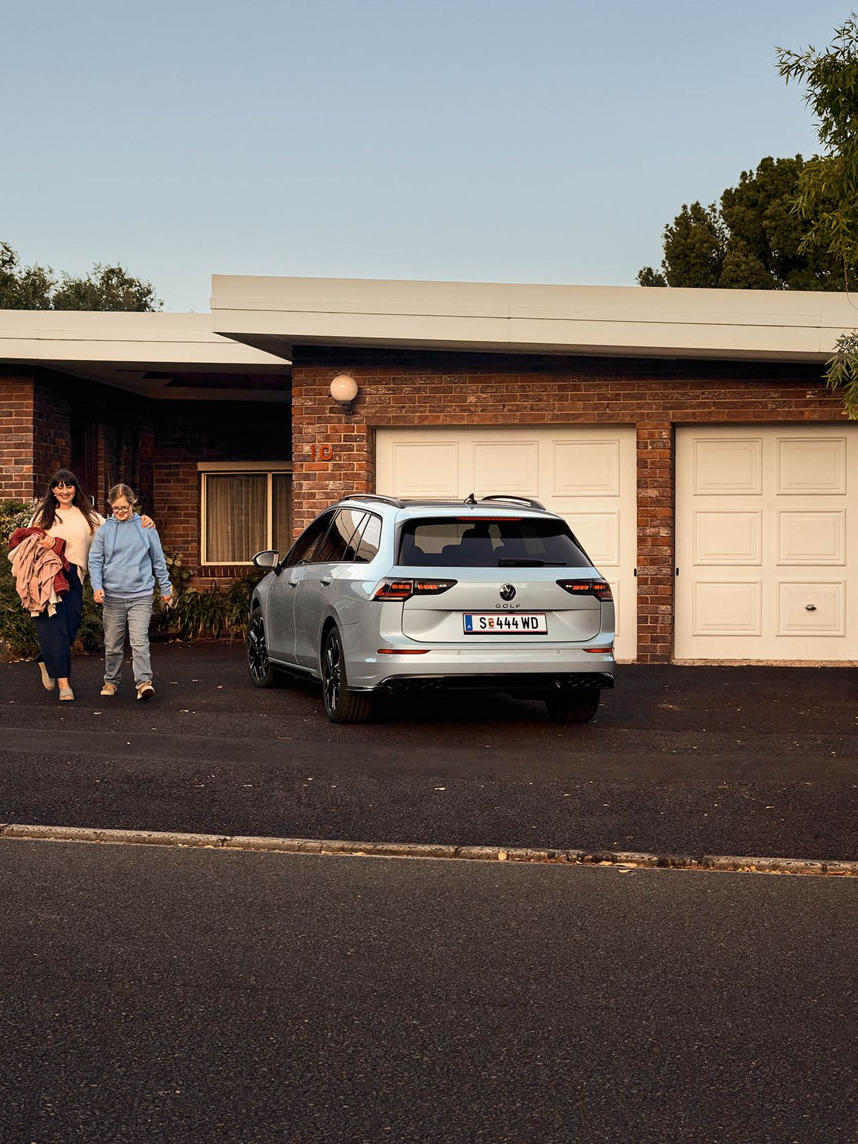 Heckansicht eines VW Golf Variant in der Farbe Ice Blue Metallic geparkt vor Einfamilienhaus