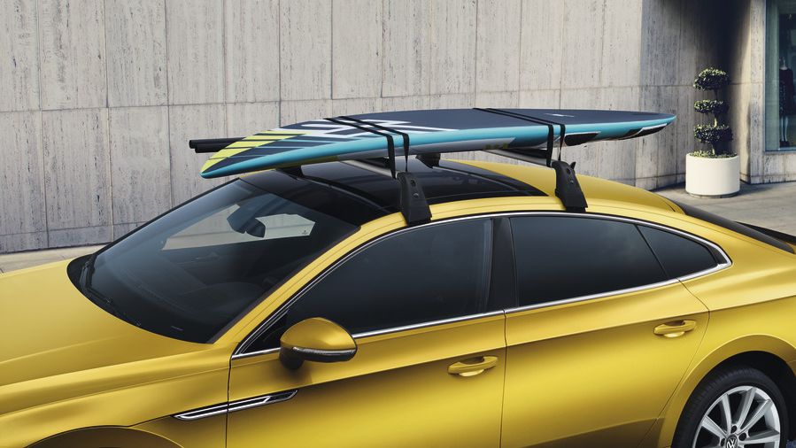 Volkswagen Surfbretthalter am Dach eines gelben VW