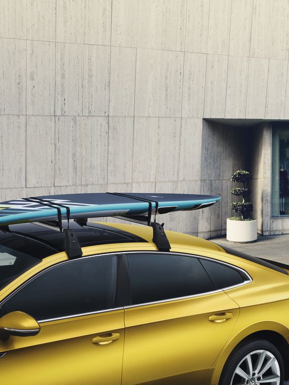 Volkswagen Surfbretthalter am Dach eines gelben VW