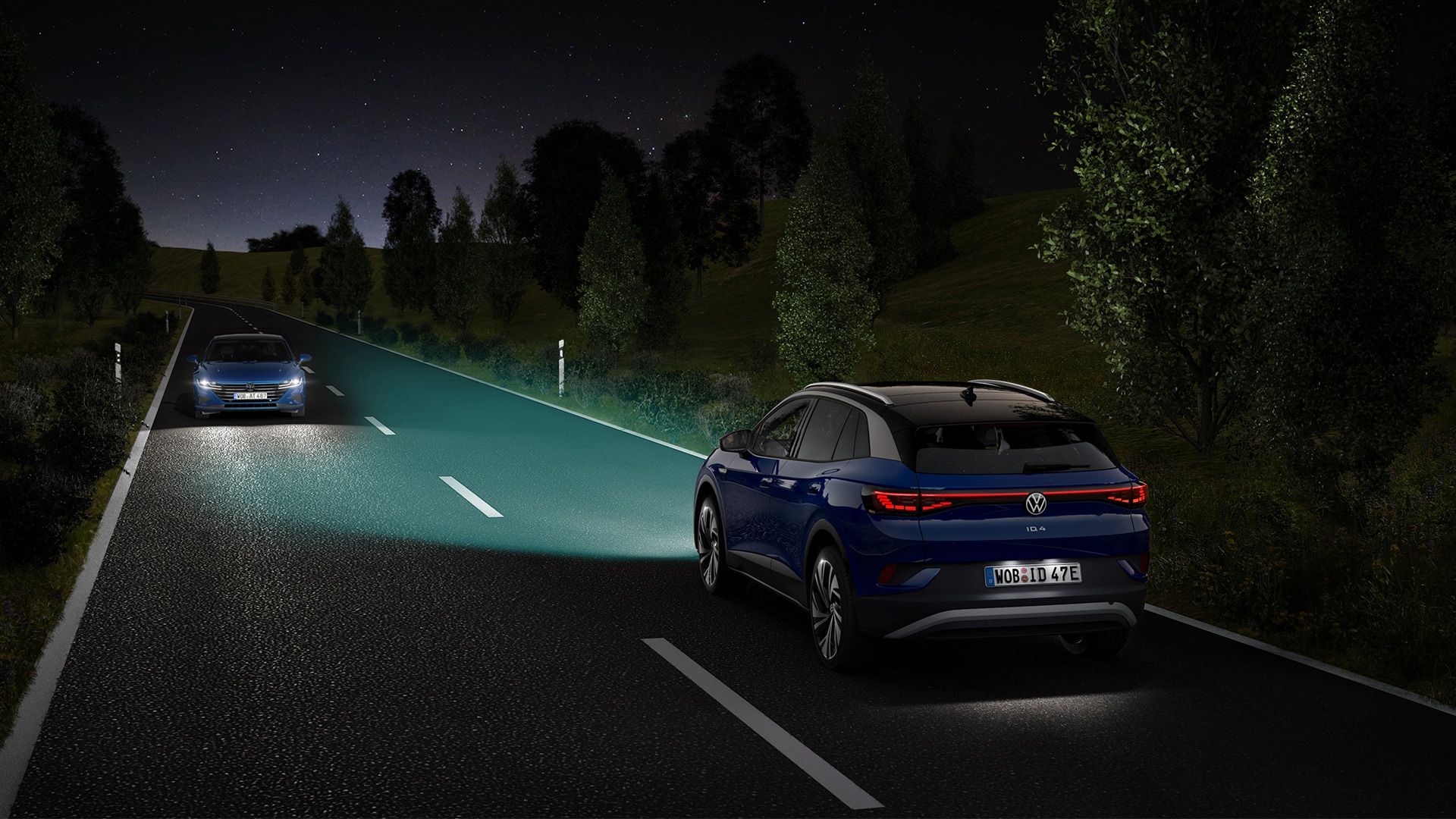 VW ID.4 fährt nachts auf einer Landstraße, hervorgehoben sind die Strahlen der Scheinwerfer