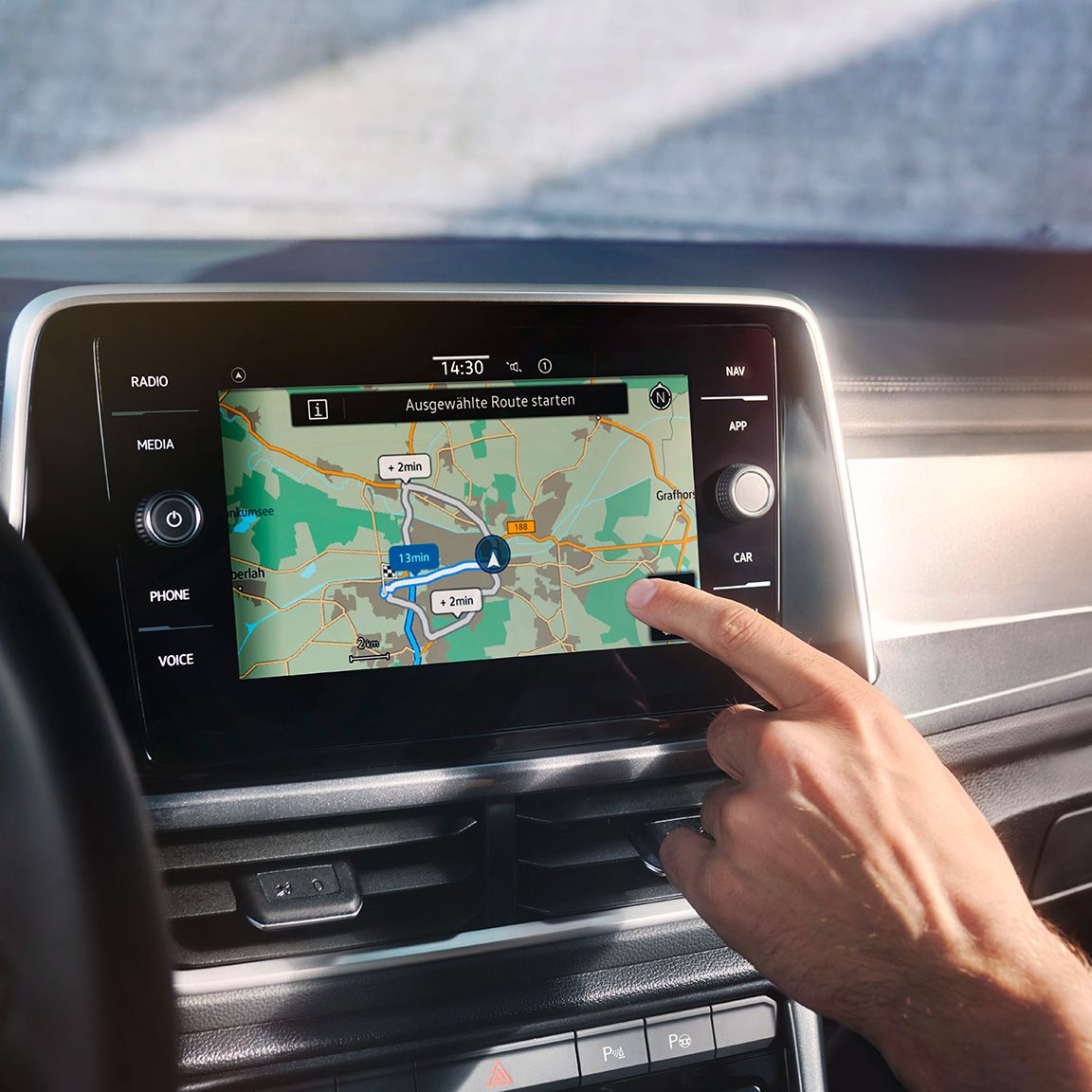 VW T-Roc Interieur, Detailansicht des Infotainment-Systems Discover Media, das gerade von einer Hand bedient wird