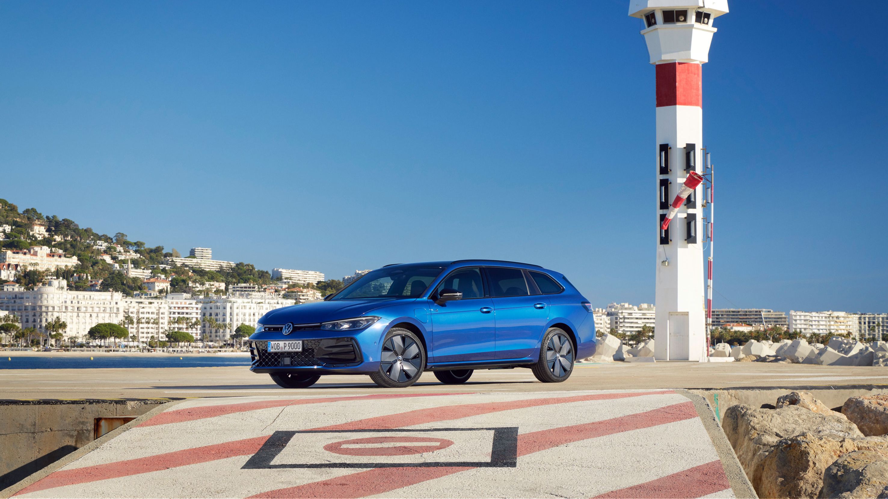 Ein blauer VW Passat steht auf einem Landeplatz am Meer. 