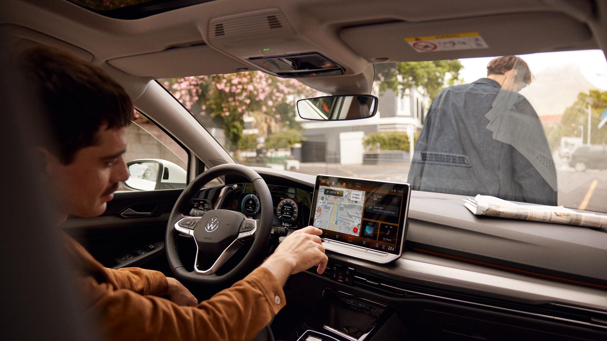 Man bedient Touchscreen des Infotainmentsystems im VW Golf