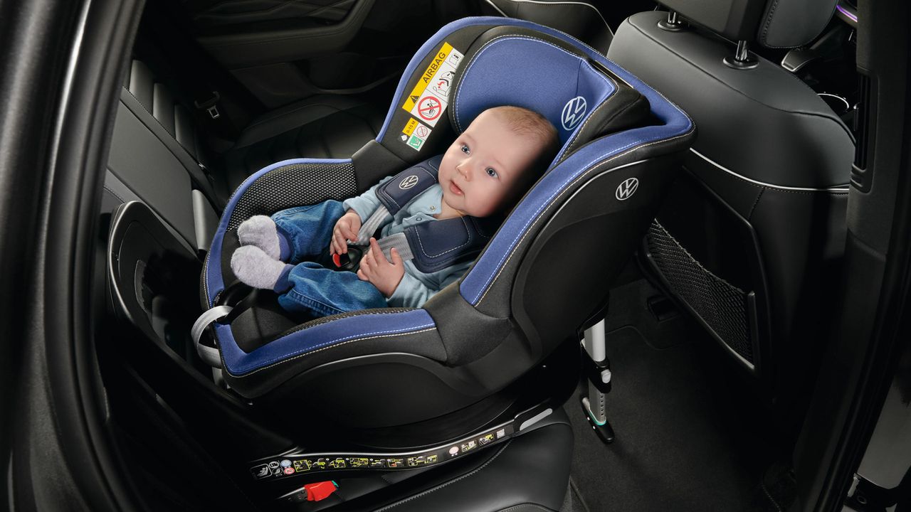 VW i-SIZE Kindersitz mit Baby auf der Rückbank gegen die Fahrtrichtung befestigt