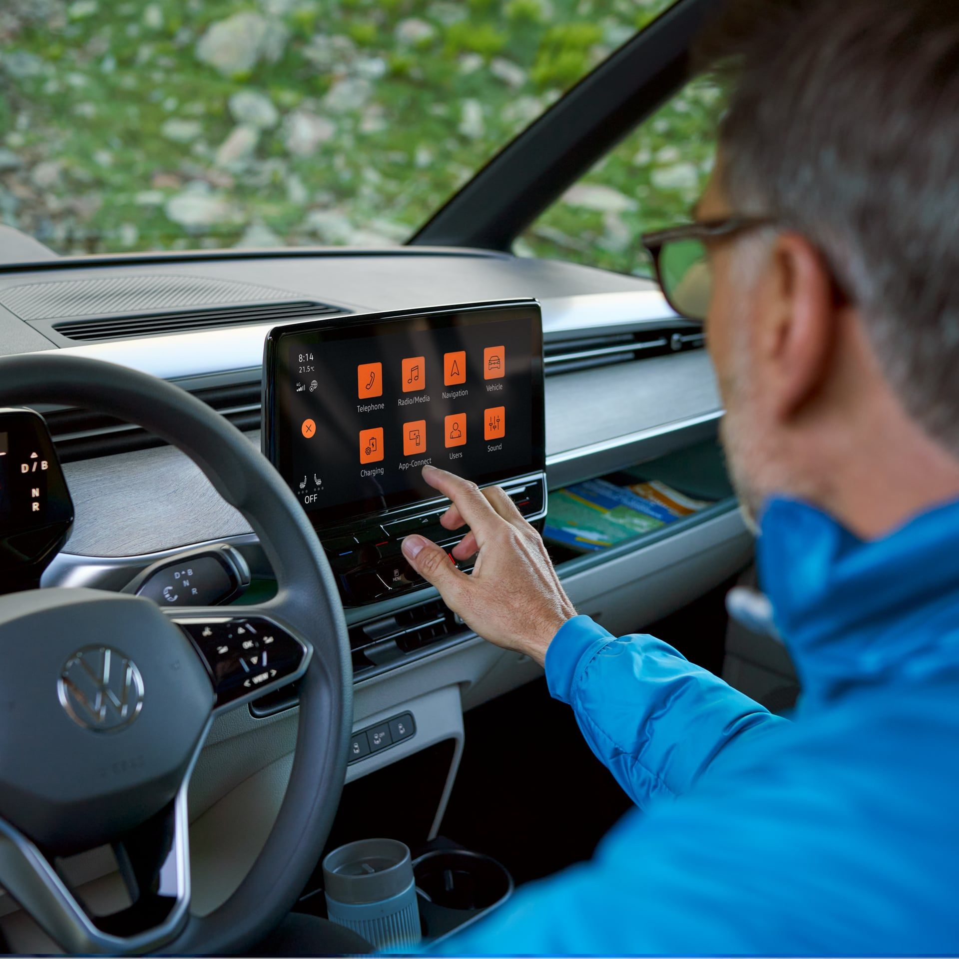 Der Fahrer bedient das Digital Cockpit des VW ID. Buzz
