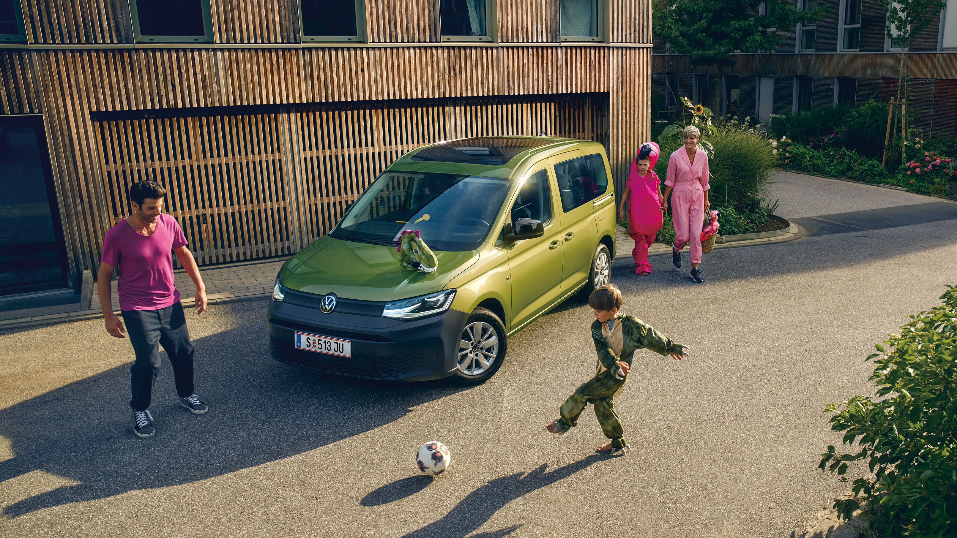Grüner VW Caddy mit Familie