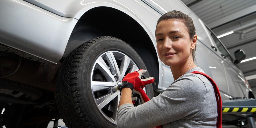 Eine Volkswagen Technikerin beim Reifenwechsel