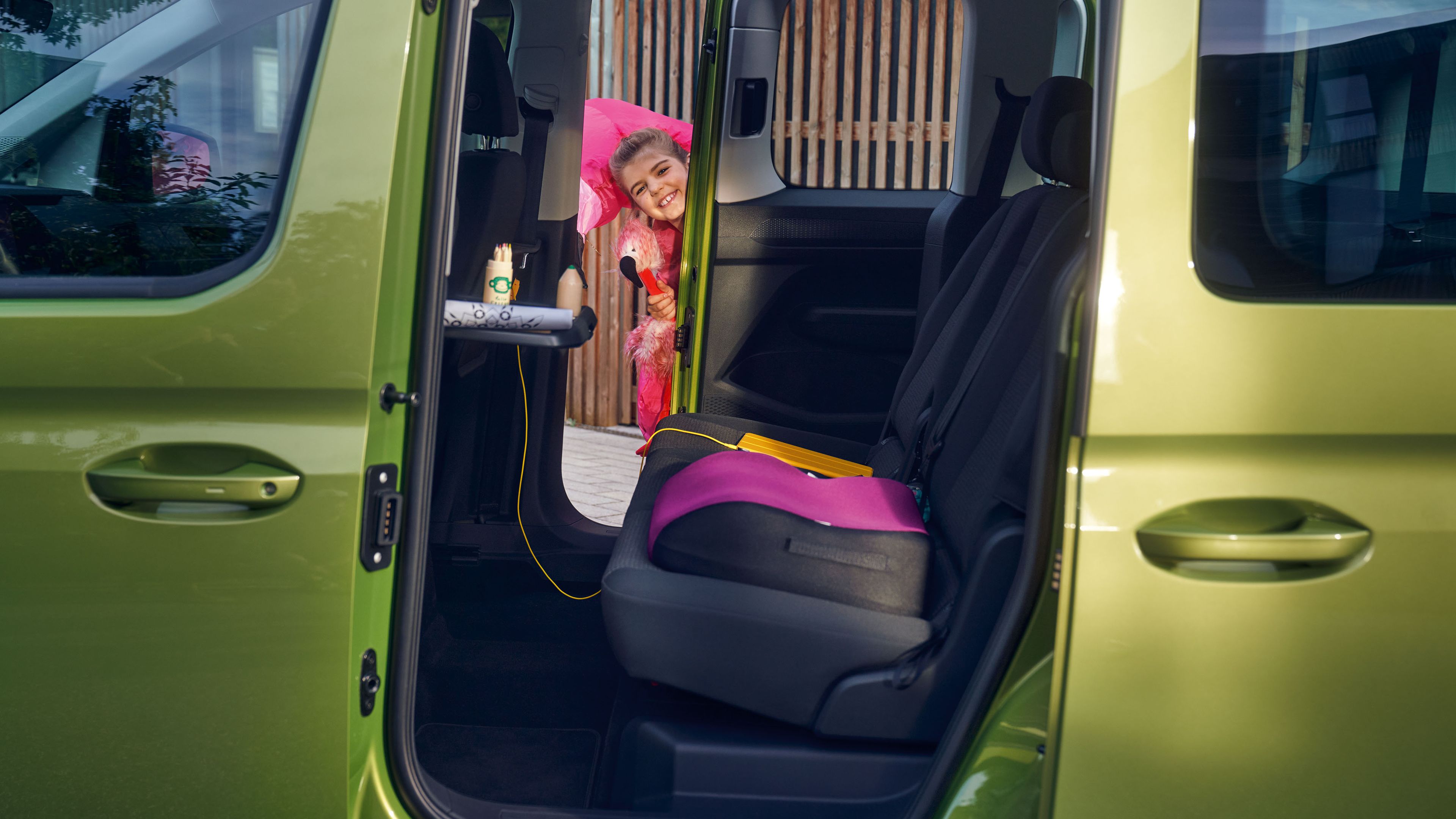 Eine Frau legt die Sitze in der zweiten Sitzreihe eines VW Caddy um.